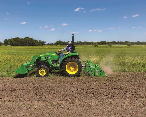 A John Deere tractor tilling a field