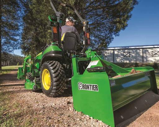 John Deere Tractor and Frontier attachment leveling a gravel driveway