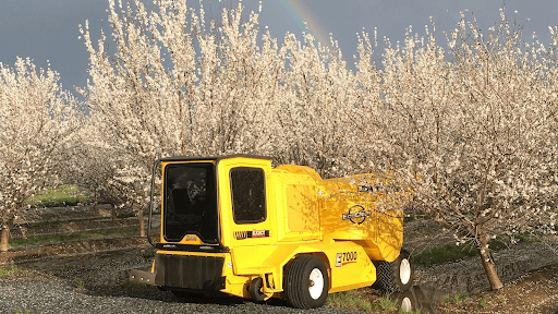 A large piece of farm equipment in an orchard