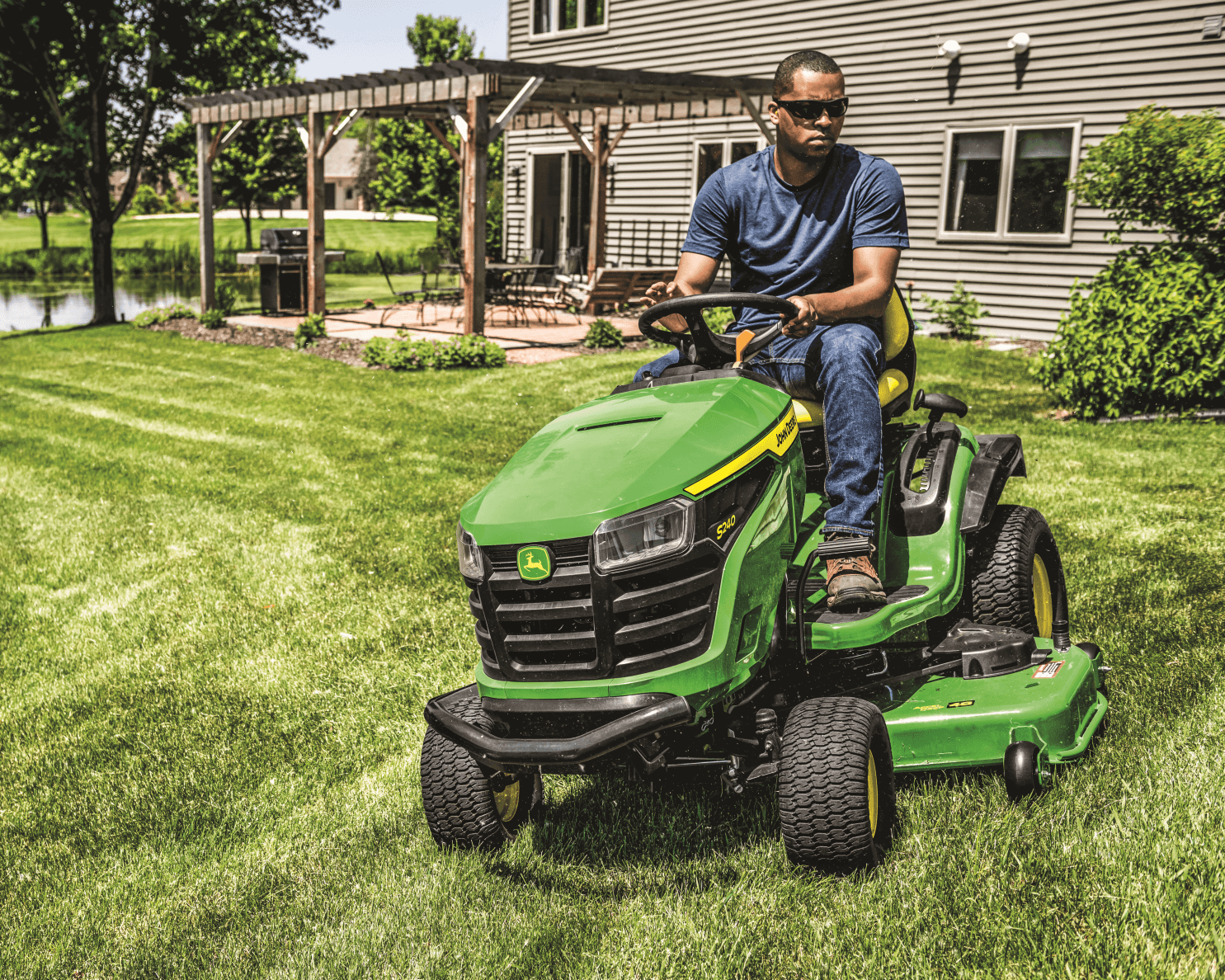 A homeowner uses a John Deere S240 lawn tractor to maintain their lawn in California.