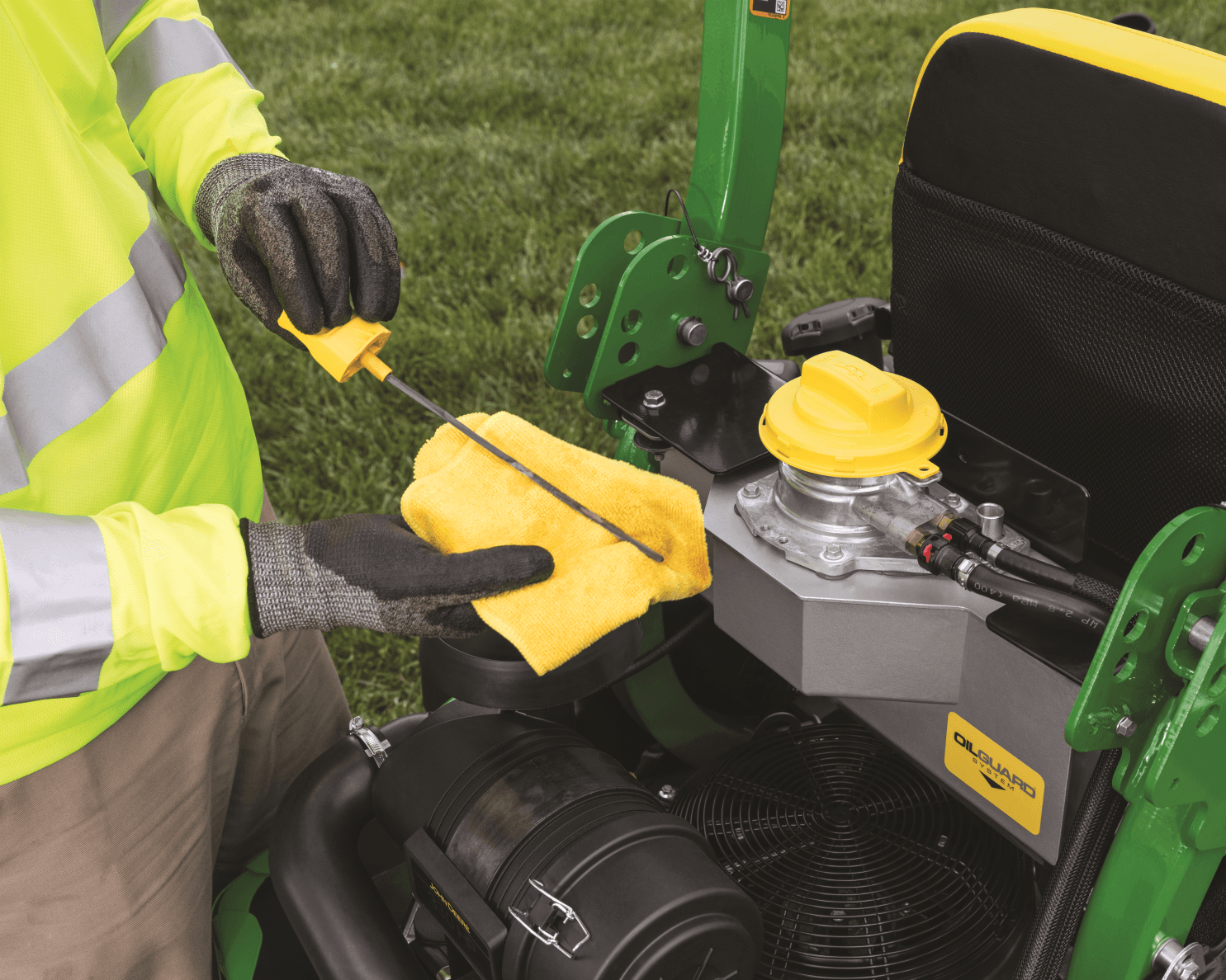 A worker inspects the oil on a zero-turn mower in California.