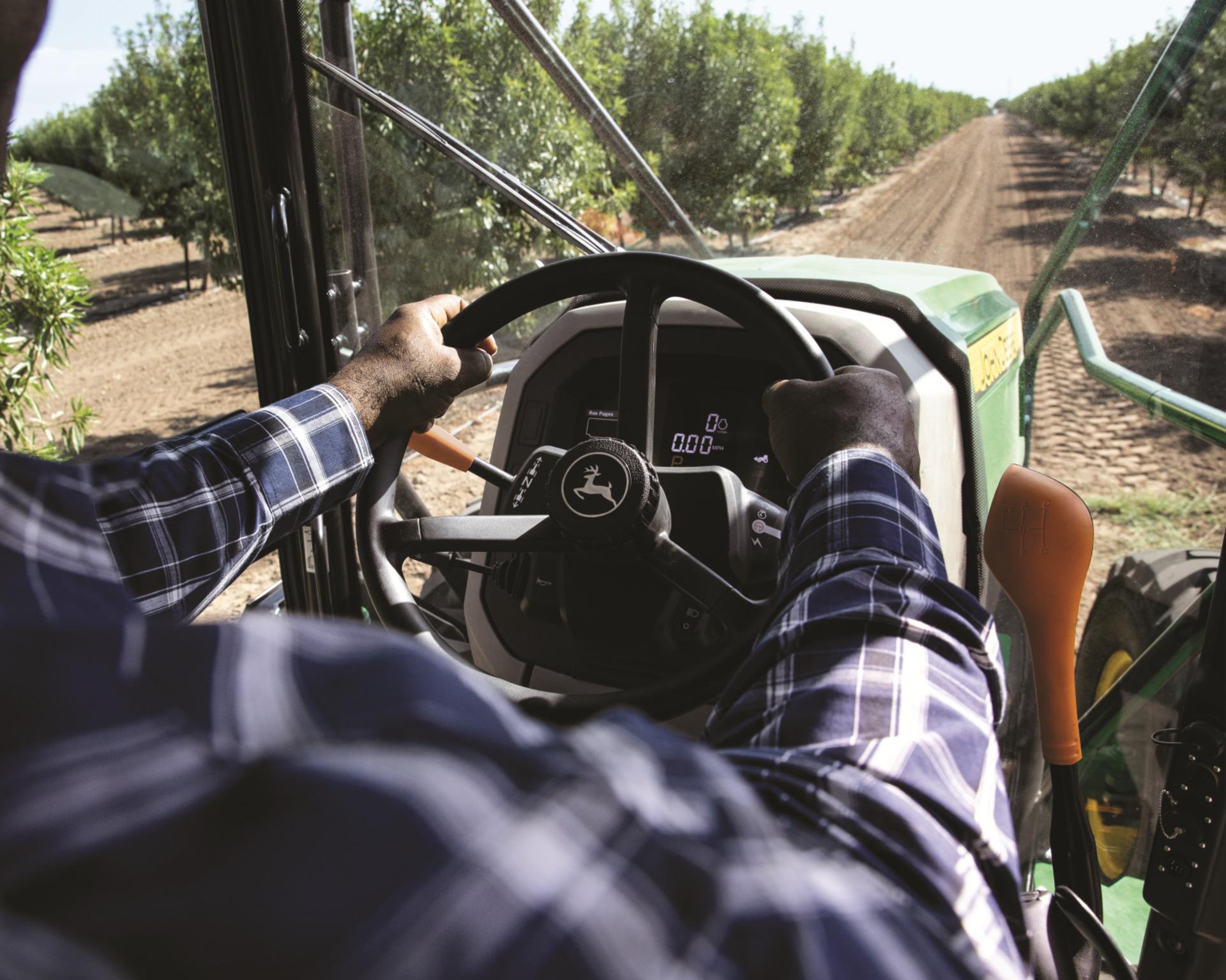 A John Deere 5ML tractor in an orchard.