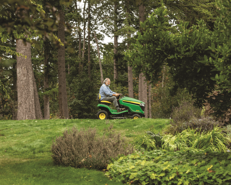 A workers uses a John Deere Z350 lawn tractor on a lawn in California.