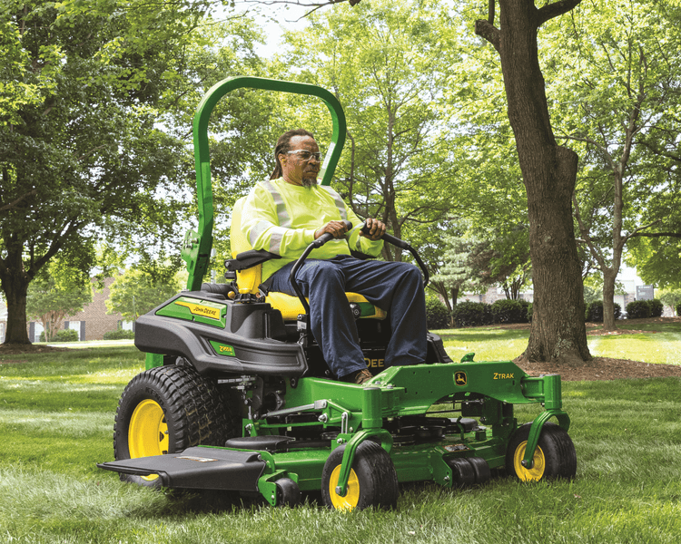 A worker mows a lawn with a zero-turn Ztrak mower in California.